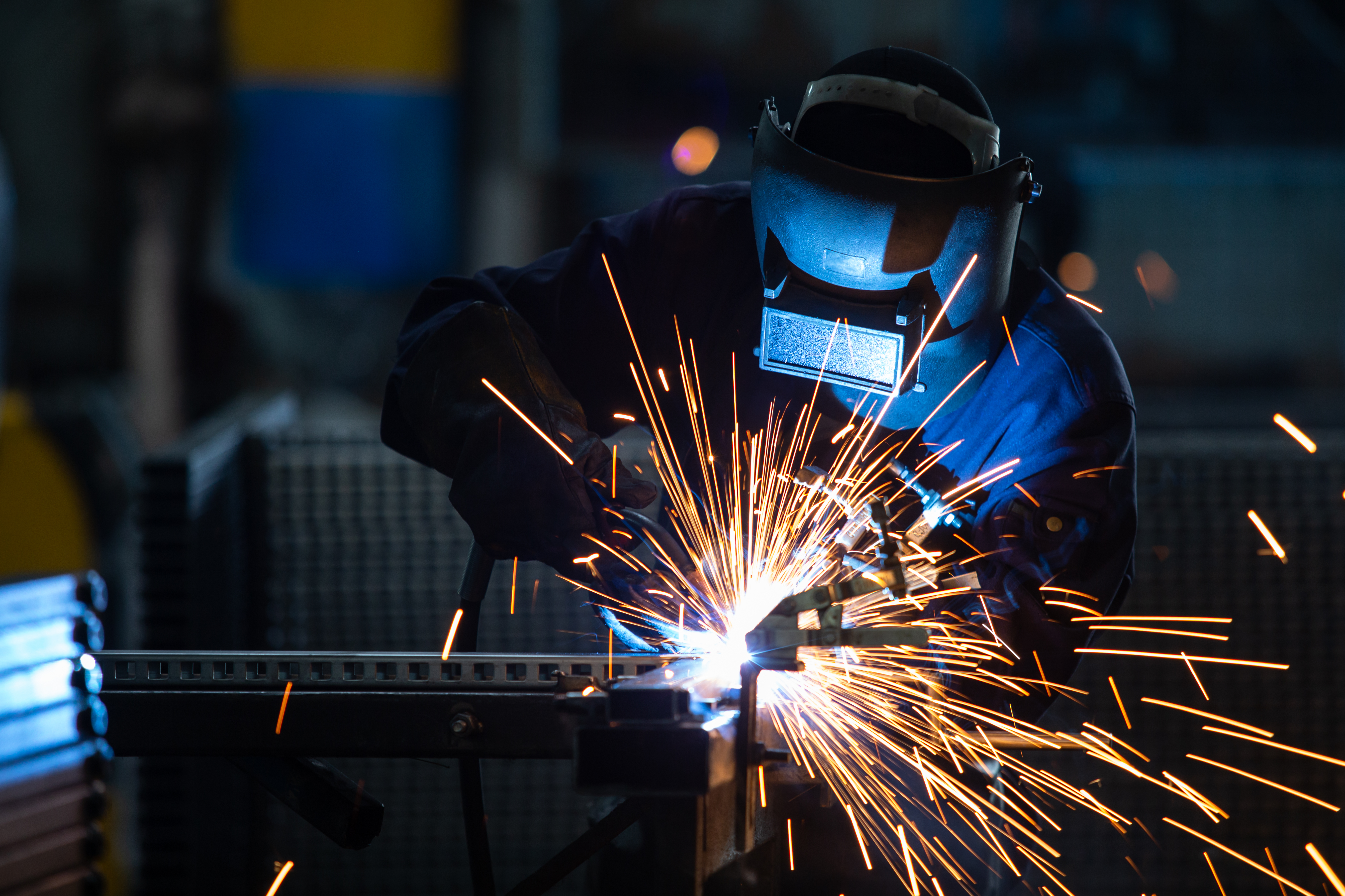 Workers,Wearing,Industrial,Uniforms,And,Welded,Iron,Mask,At,Steel